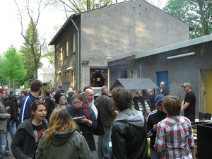 Ein Überblick über das Grillfest mit vielen Menschen - im Hintergrund steht der Lachsgrill