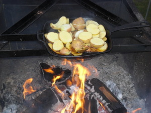Bratkartoffeln in einer Gusspfanne über dem Feuer