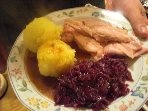 Ein Teller mit Klößen, Rotkohl, Schweinebraten und Sauce