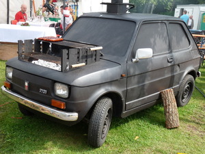 Ein alter Fiat komplett Schwarz - in die Motorhaube ist ein Grill gebaut