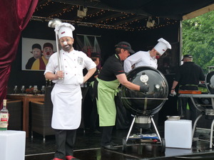 Ein Clown mit einer großen Kelle in der Hand und ein anderer Clown am Grill