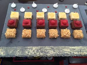 6 Portionen a Drei Stück Kuchen symetrisch auf einer Schieferplatte angerichtet. Am unteren Rand Gold-Glitzer