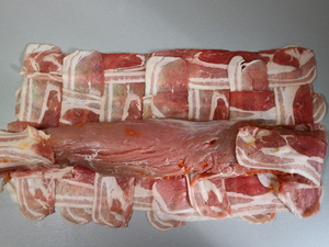 Schweinefilet wird in Geflecht aus Baconscheiben eingerollt