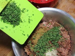 Kräuter werden zur Wurstmasse gegeben