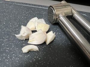 Knoblauchzehen und Knoblauchpresse