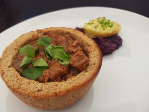 Gulasch im Brot mit Rotkohl und Kartoffel