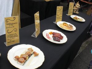 Präsentationstisch mit angerichteten Tellern und handbeschrifteten Tafeln