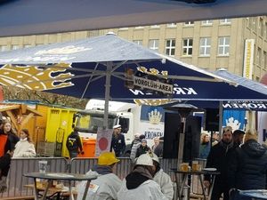 Kronen-Schirme und Besucher auf dem Wettbewerbsplatz