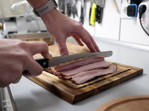 Der fertige Bacon wird in dünne Scheiben geschnitten