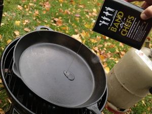 Öl wird in die Gusseisenpfanne auf dem Grill gegeben