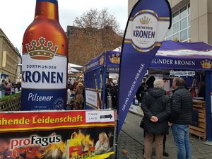 Große Kronen-Pils-Flasche und Werbebanner am Eingang