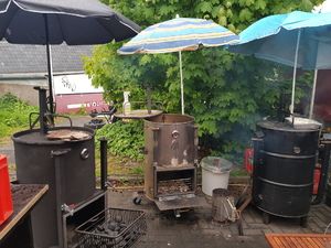 Fass-Smoker und Grills unter Sonnenschirmen
