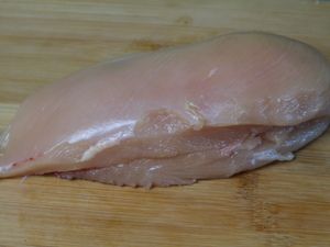 Rohe Hähnchenbrust auf einem Holzbrett