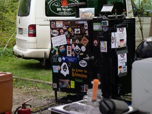 Mit Aufklebern beklebter Smoker vor einem Transporter