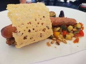 Bratwurst mit Parmesanhippe auf Grillgemüse
