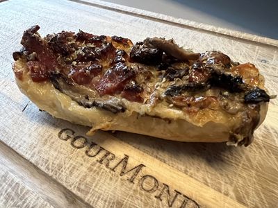 Überbackenes Pizza-Baguette auf einem GourMonds-Brett