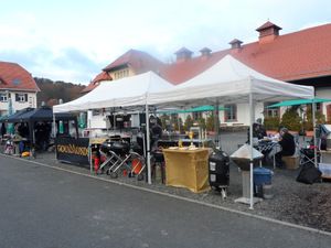Weiße Pavillons der Grillteams auf dem Hof vor roten Dächern