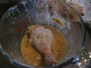 Hähnchenkeule wird durch die Eimasse gezogen