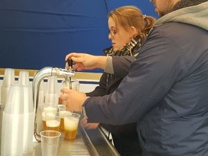 Bier wird am Zapfhahn in Becher gezapft