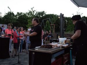 Grillkurs: Teammitglieder zeigen das Fleisch am Grilltisch