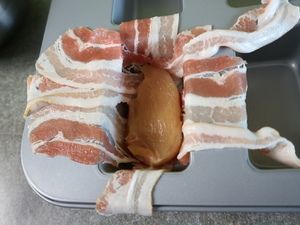 Hähnchenbrust auf dem Speckgitter in der Form
