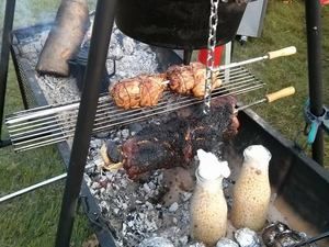 Fleisch am Drehspieß und im Topf über offener Glut