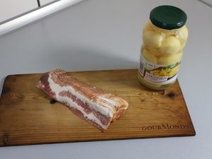 Speckscheiben und ein Glas Kartoffeln auf dem Brett