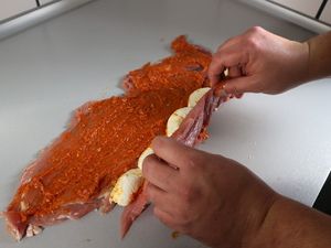 Schweinefilet wird mit Mozarella zusammengerollt