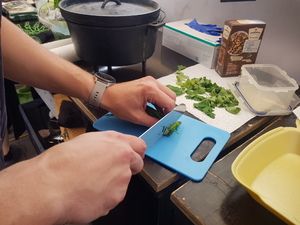 Kräuter werden auf einem blauen Brett gehackt