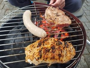 Wurst, Nackensteak und Hähnchenbrust auf dem Grillrost