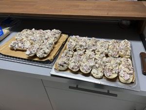 Belegte Pizza-Baguettes auf zwei Blechen