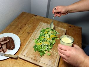 Salat wird mit dem Dressing beträufelt