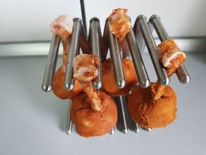 Rohe, gewürzte Lollipops am Keulenhalter vor dem Grillen