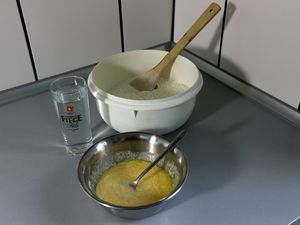 Eine Plastikschüssel, eine Metallschüssel und ein Glas Wasser