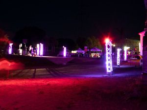Bunt beleuchtete Stelen auf dem Gelände bei Nacht