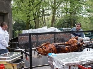 Hendrik (links) und Dennis (rechts) nehmen ein gut gebräuntes Schwein vom Grill