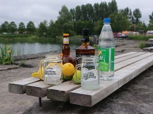 Drinks und Flaschen auf einem Holzsteg am See