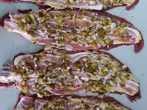 Gurken- und Zwiebelwürfel auf den Rouladen