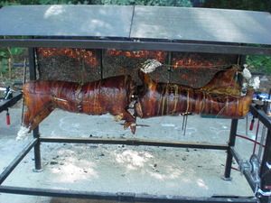 Zwei gut gebräunte Schweine ohne Kopf auf einem Schweinegrill