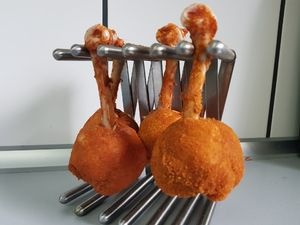 Chicken Lollipops an einem Edelstahl-Keulenhalter