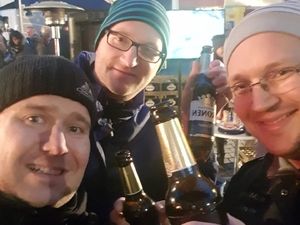Drei Teammitglieder mit Mützen beim Selfie mit Bierflaschen