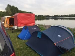 Zelte und Anhänger am See