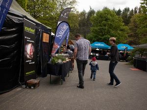 Besucher zwischen den Ständen mit Werbefahnen