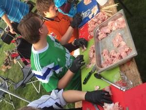 Kinder mit Handschuhen bereiten rohes Fleisch vor