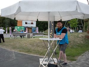 Aufbau mit Stehtischen und Sonnenschirm auf dem Gelände