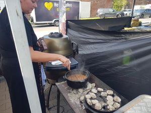Topf mit Soße auf dem Grill, daneben Knödel