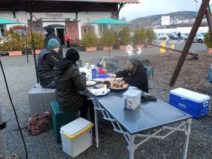 Frühstück am Campingtisch zwischen Kühlboxen am Morgen