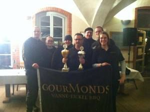 Das Team mit Pokalen hinter dem GourMonds-Banner