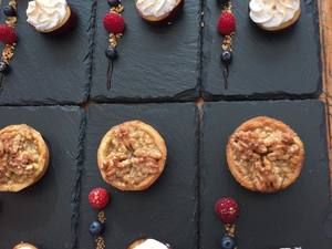 Kleine Törtchen und Beerenspieße auf Schieferplatten