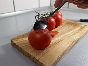 Die Tomate wird mit einem Löffel ausgehöhlt
